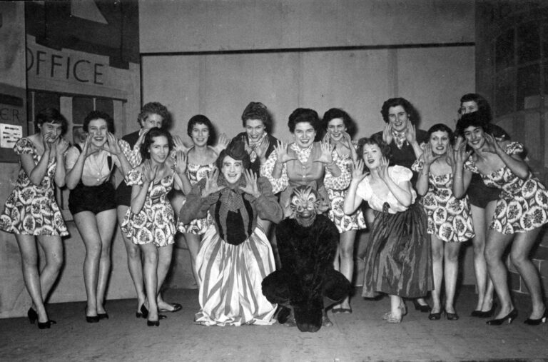 Puss in Boots 1956: Puss the cat crouching in front of the Dame and the chorus girls, all with hands up like claws