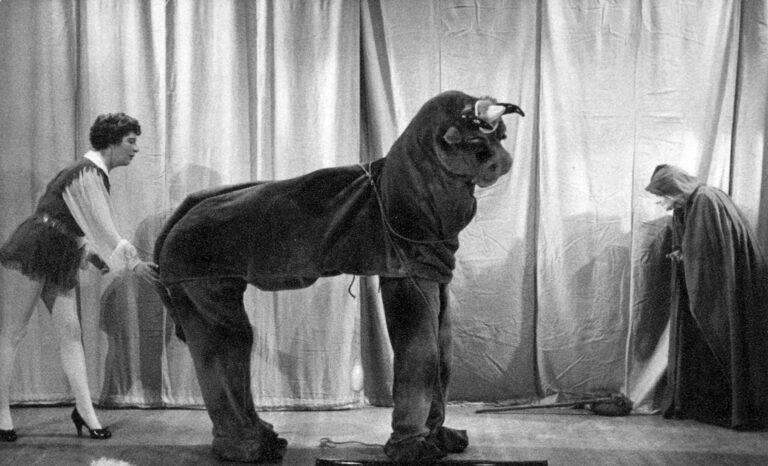 Jack and the Beanstalk 1959: Jack leading the pantomime cow across the stage, with a cloaked figure kneeling on the right